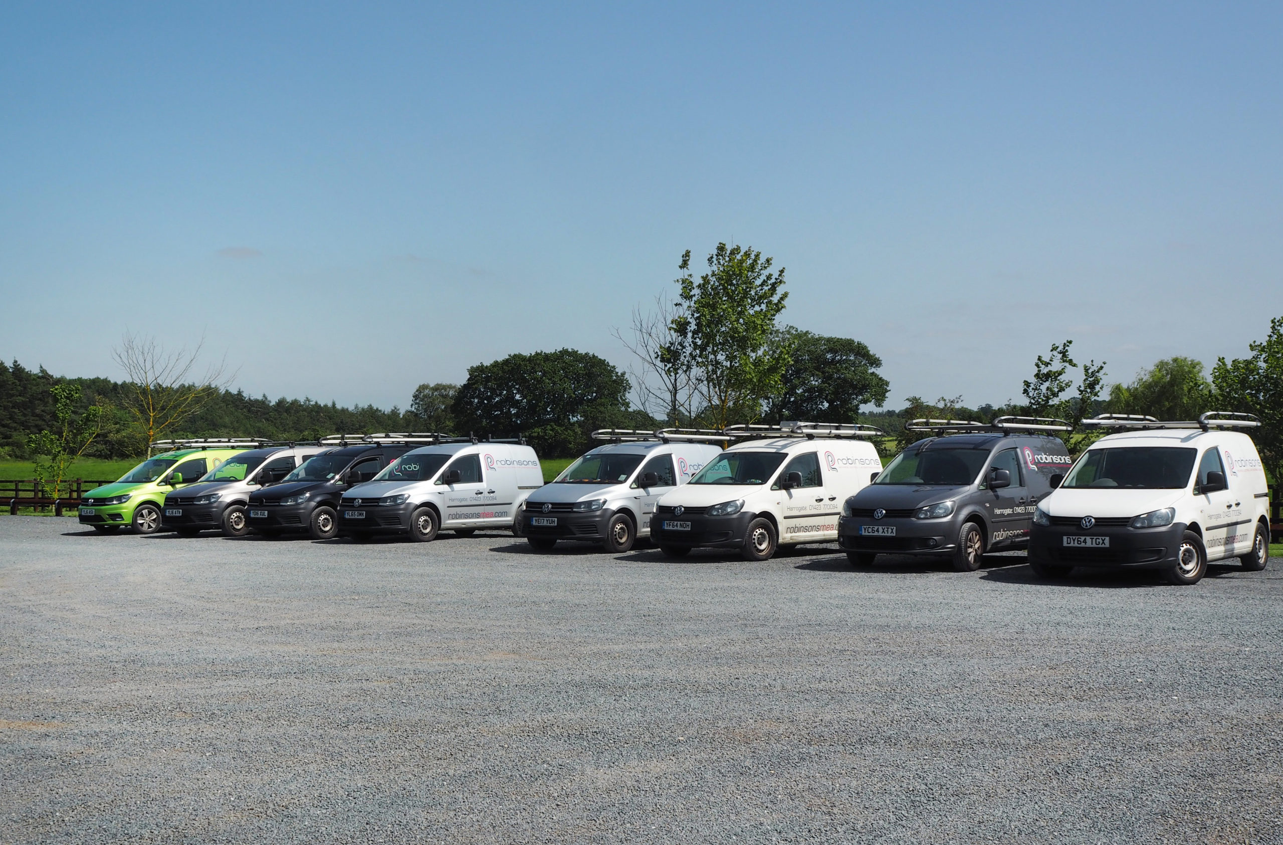 A front three-quarter view of a row of Robinsons-branded service vans parked outdoors